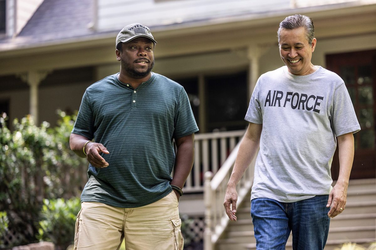 Two veterans chat and go for a walk on a warm day.