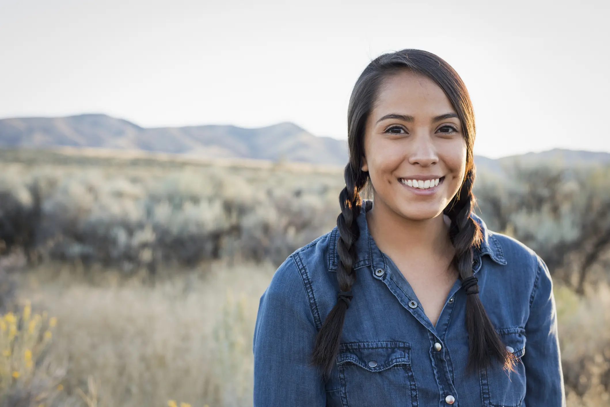 Native American woman smiles while standing outdoors
